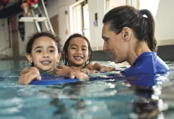 girls with swim instructor in pool