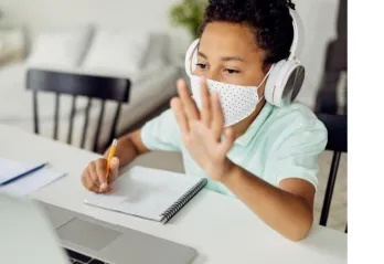 child waving during remote learning on screen