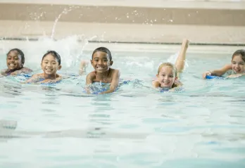 Children swimming together in a pool.