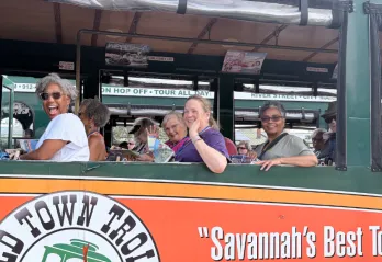 Members of the YMCA on a trip, participating in a Trolley ride smiling and waving