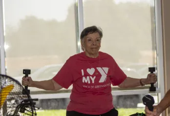 Women happily working out with weights in a SilverSneakers class