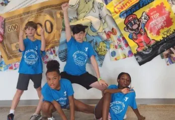 Group of children posing in front of a artistic wall 