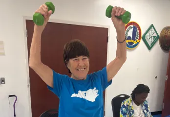 Women smiling holding weights over her head