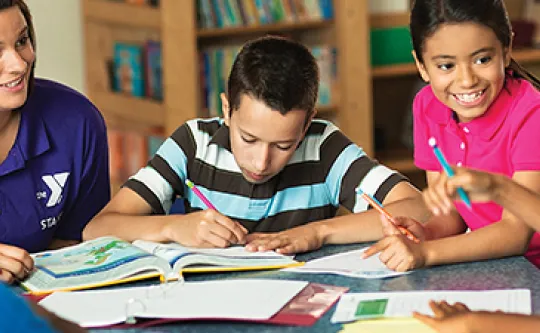 A group of students sit together while working on school work.