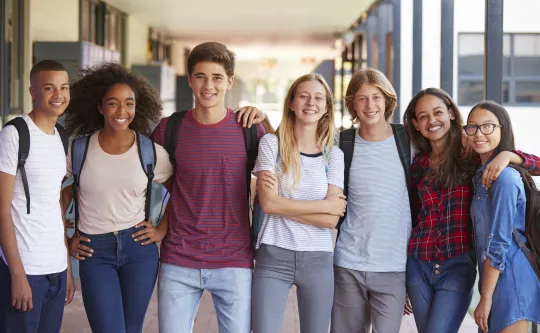 A diverse group of teenagers standing together.