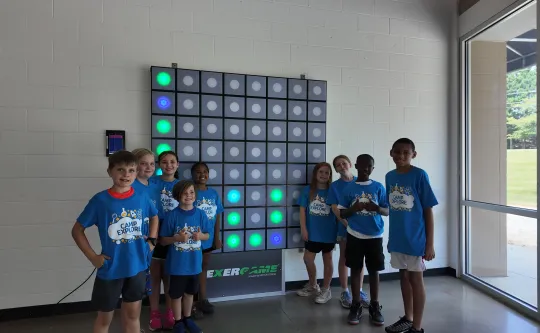 A diverse group of children playing in the Exergaming Room at the Spears Y.