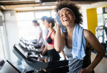 A woman smiling while she exercises at the gym.
