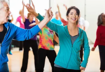 A group of people smiling and laughing while dancing.