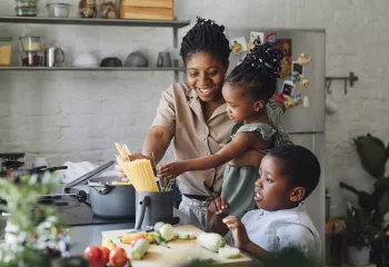 A family cooking together in the kitchen.