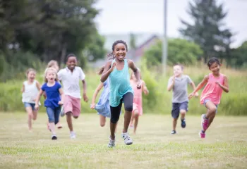 A group of children running outside.