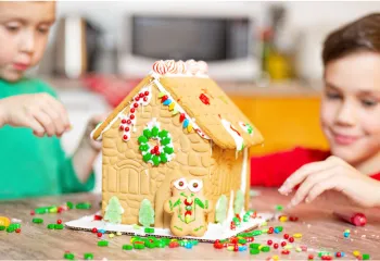 Two young boys build a gingerbread house together