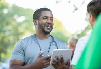 A doctor talks with a member of the community during a health fair event.