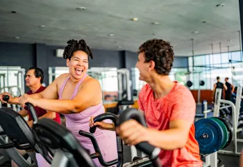 Two people on the elliptical machine in wellness center
