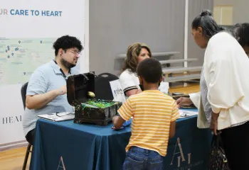 Community members connect with a vendor at an information booth during the Senior Expo at the Ragsdale YMCA, highlighting resources and engagement for older adults and families.