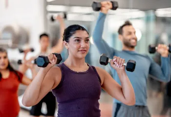 A woman using hand weights in a group exercise class.