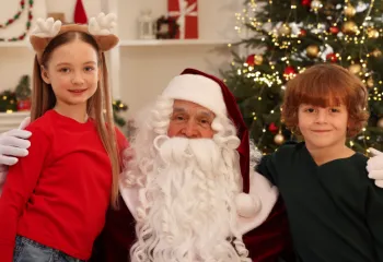 Two kids sitting and smiling with Santa