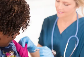 Nurse giving a woman a vaccine shot