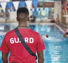A YMCA lifeguard observes the pool.
