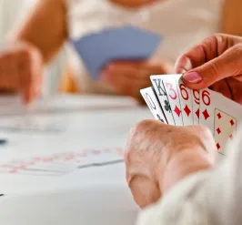 A close up photo of a senior woman's hand while she plays a card game.