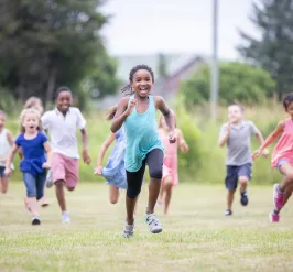 A group of children running outside.