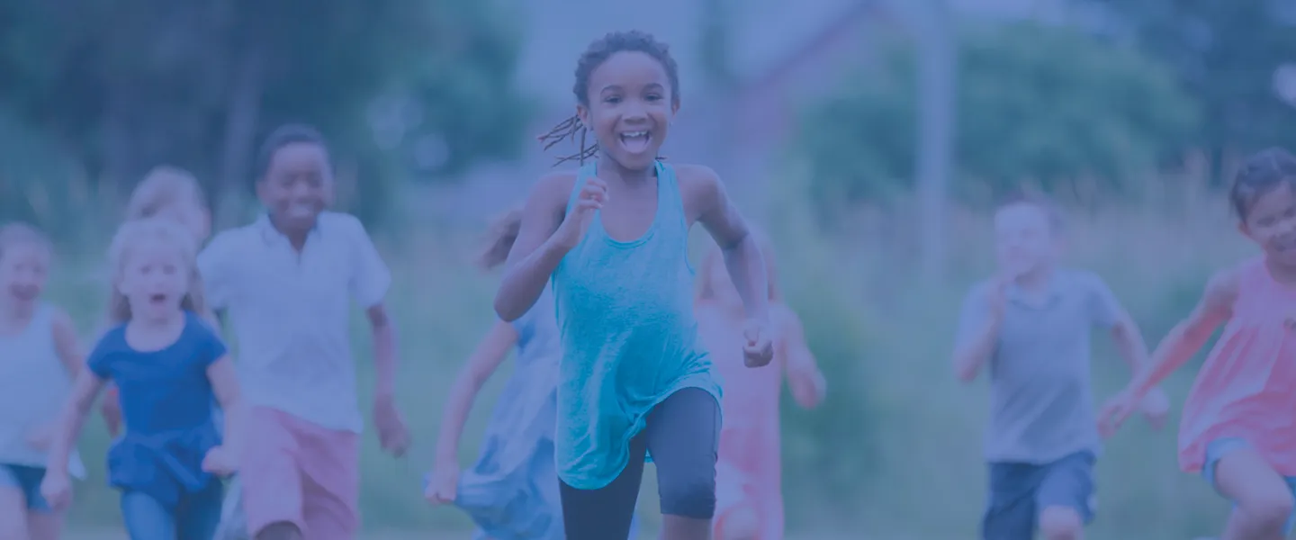 A group of children smiling and laughing as they play outside. They are running toward the camera. The photo is covered in a dark blue overlay.