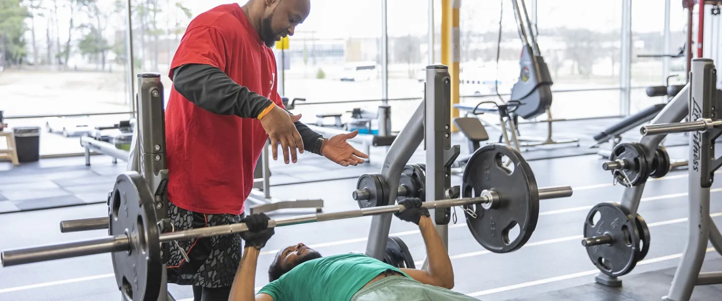 A man acting as a spotter for another man while he lifts weights at the Hayes-Taylor YMCA.
