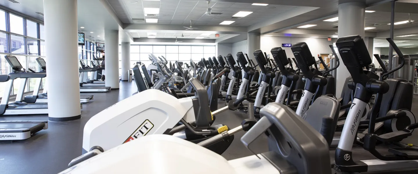 A photo of the Bryan YMCA's wellness center. There are three rows of exercise machines featured in the photo and more at the right edge of the photo.