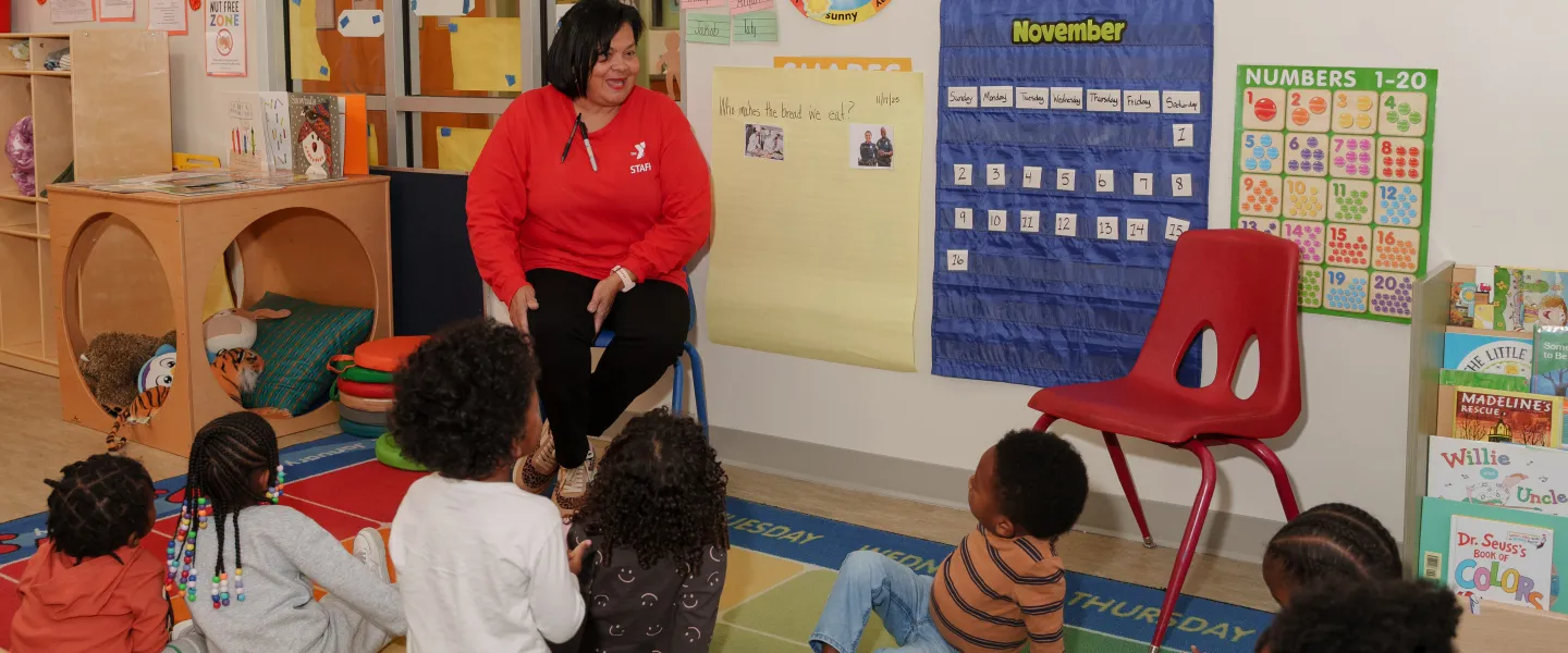A photo of a teacher and group of children in the Hayes-Taylor YMCA's Kiddie College preschool program.