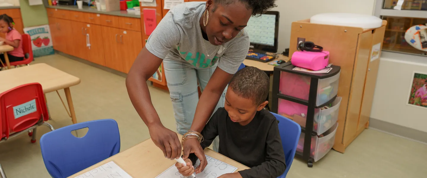 A teacher helps a student at the Hayes-Taylor YMCA's Kiddie College preschool program.