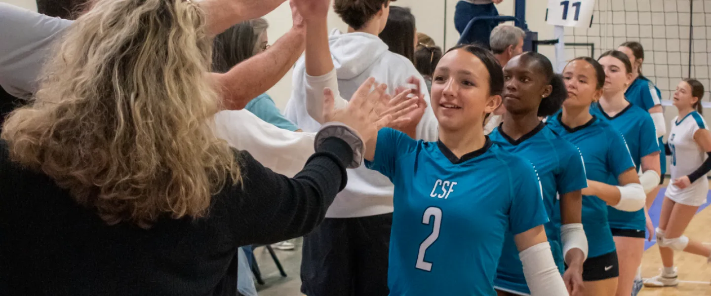 Carolina Spike Force volleyball athletes high fiving parents for game entrance