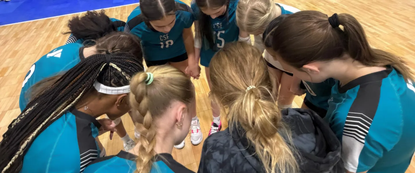Carolina Spike Force volleyball athletes huddled in a circle