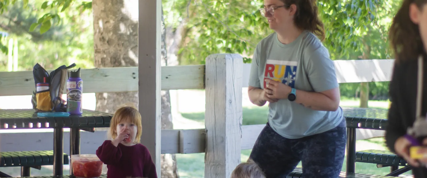 Mother working out outdoors with children playing on the ground with toys