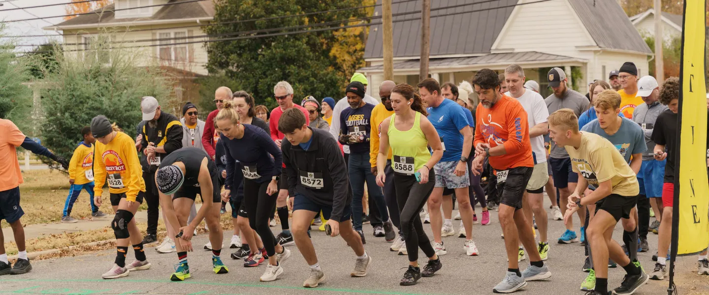 A diverse group of people at the starting line during the Reidsville YMCA Turkey Trot.