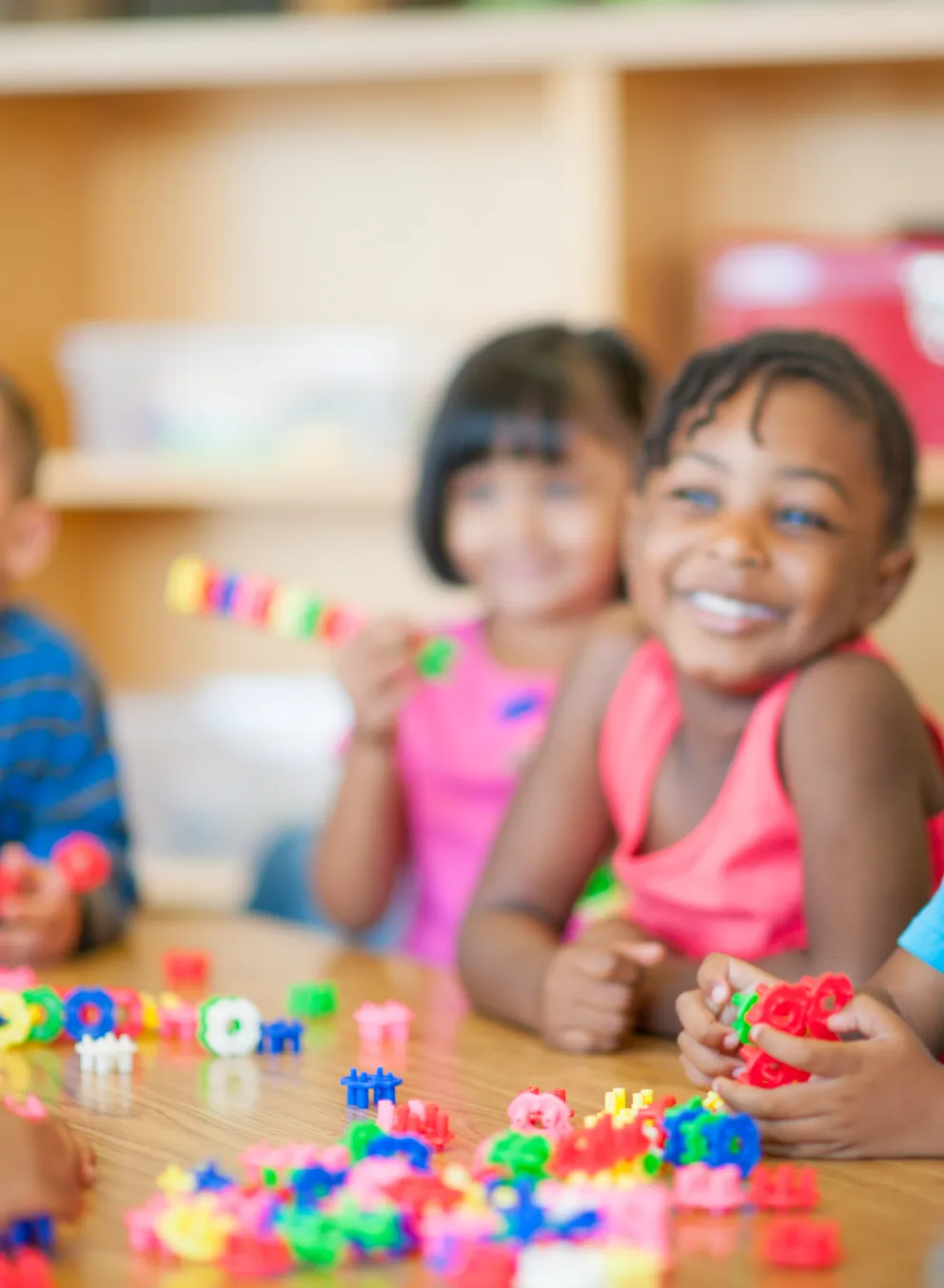 A diverse group of young children playing together at a table.