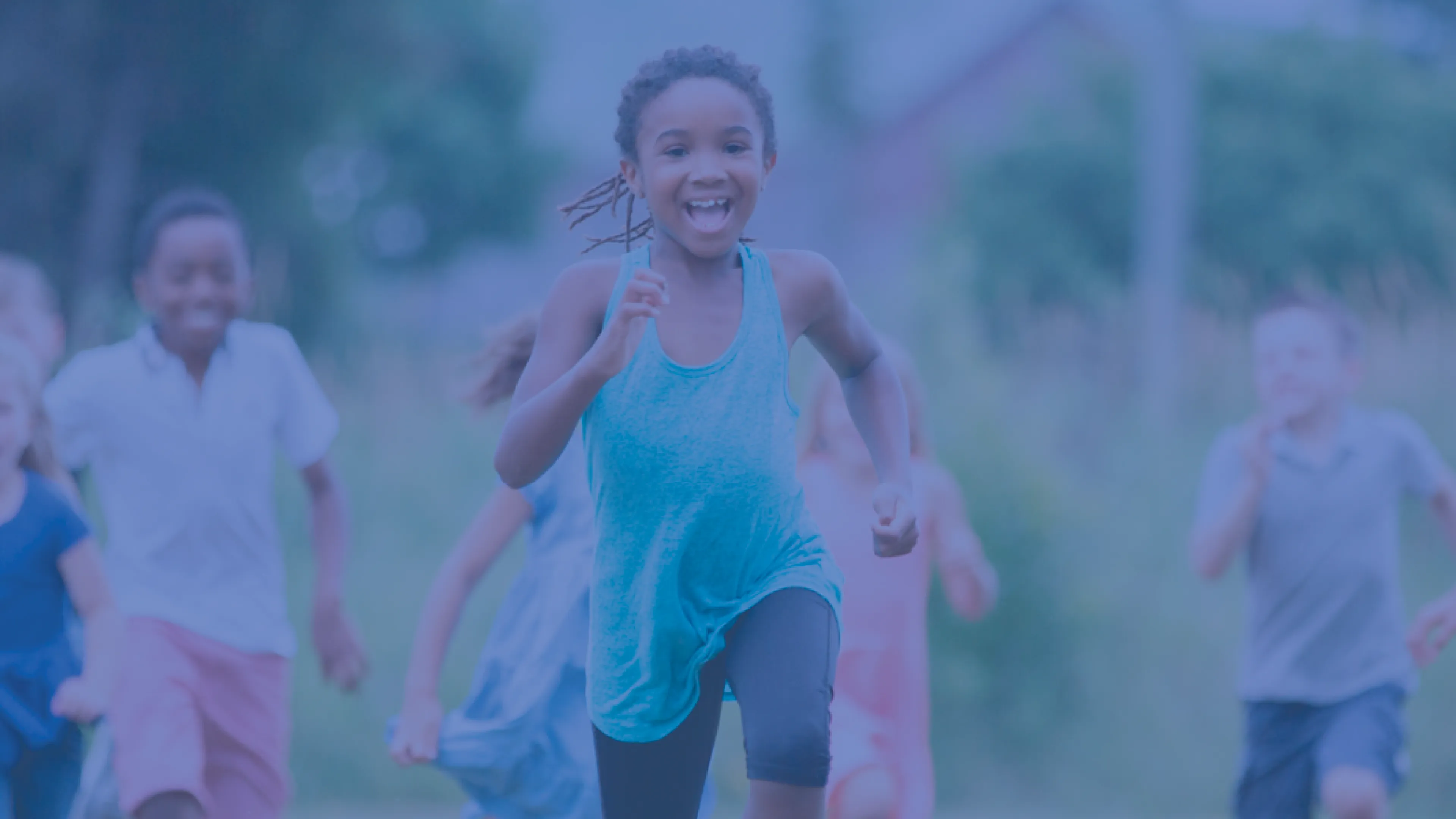 A group of children smiling and laughing as they play outside. They are running toward the camera. The photo is covered in a dark blue overlay.