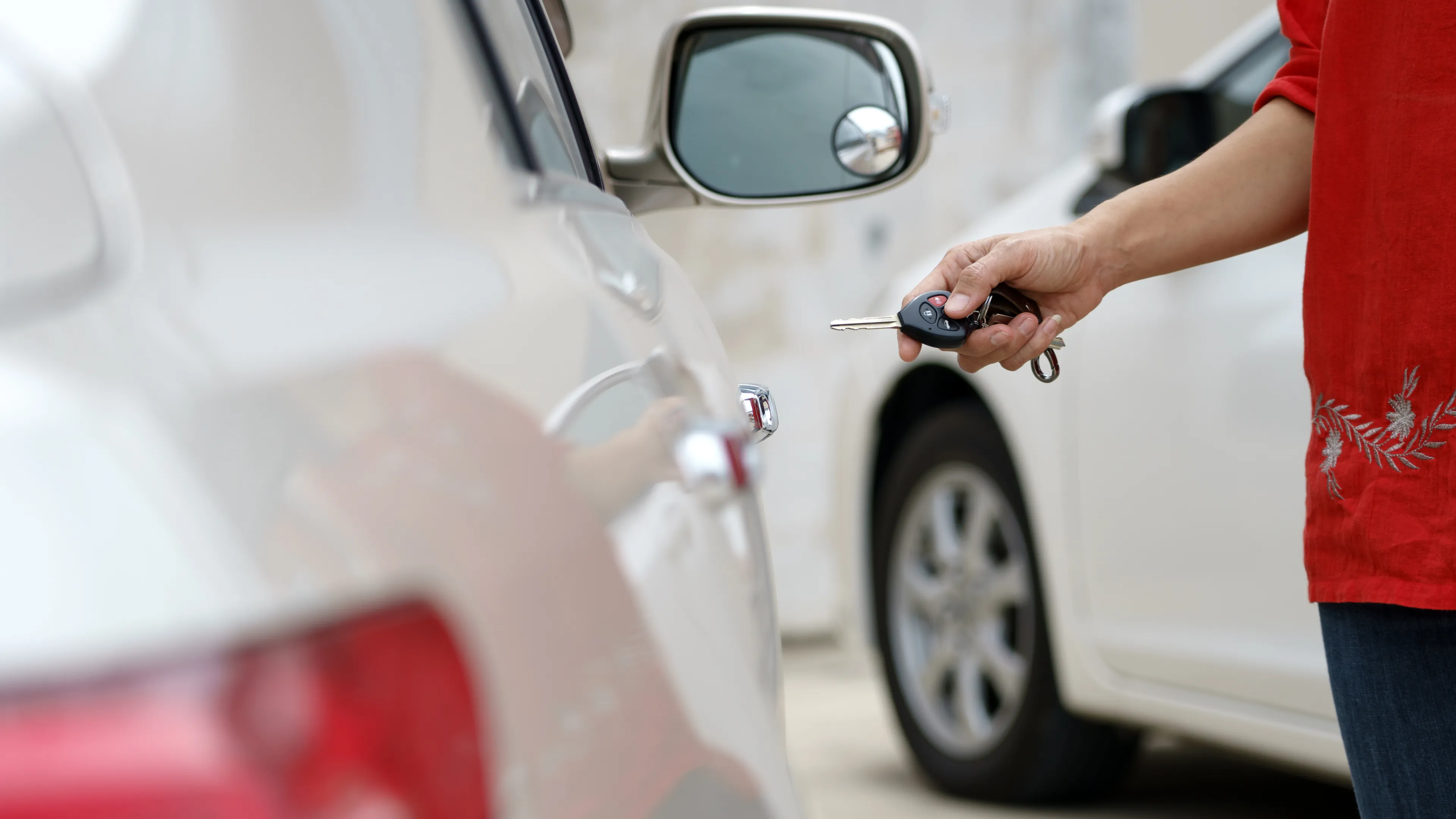 Person unlocking car with key.