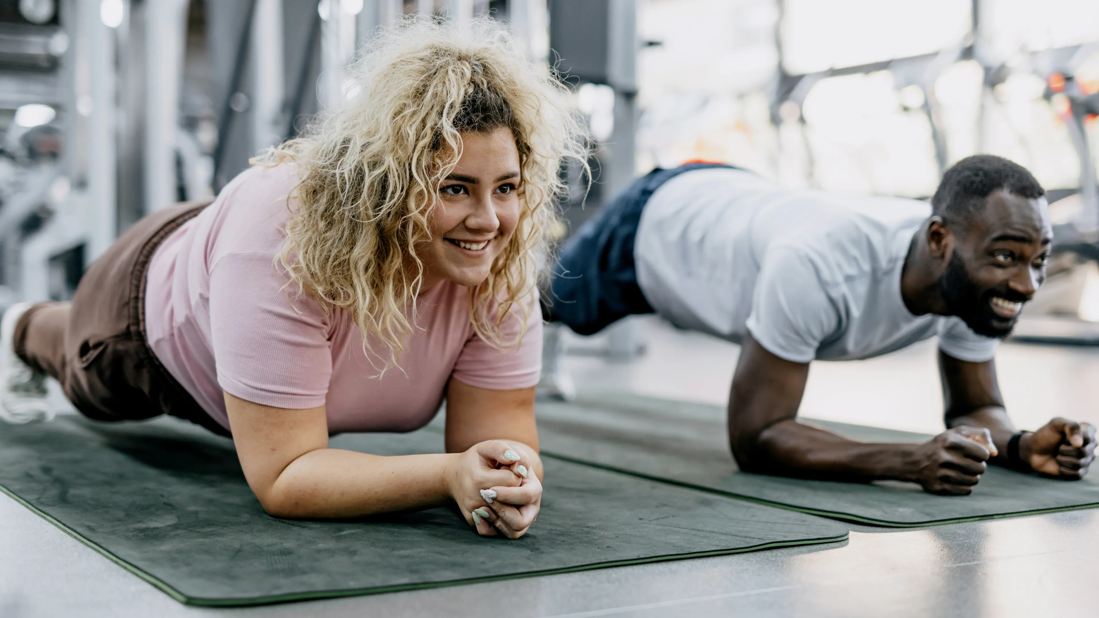woman and man doing planks at gym during personal training