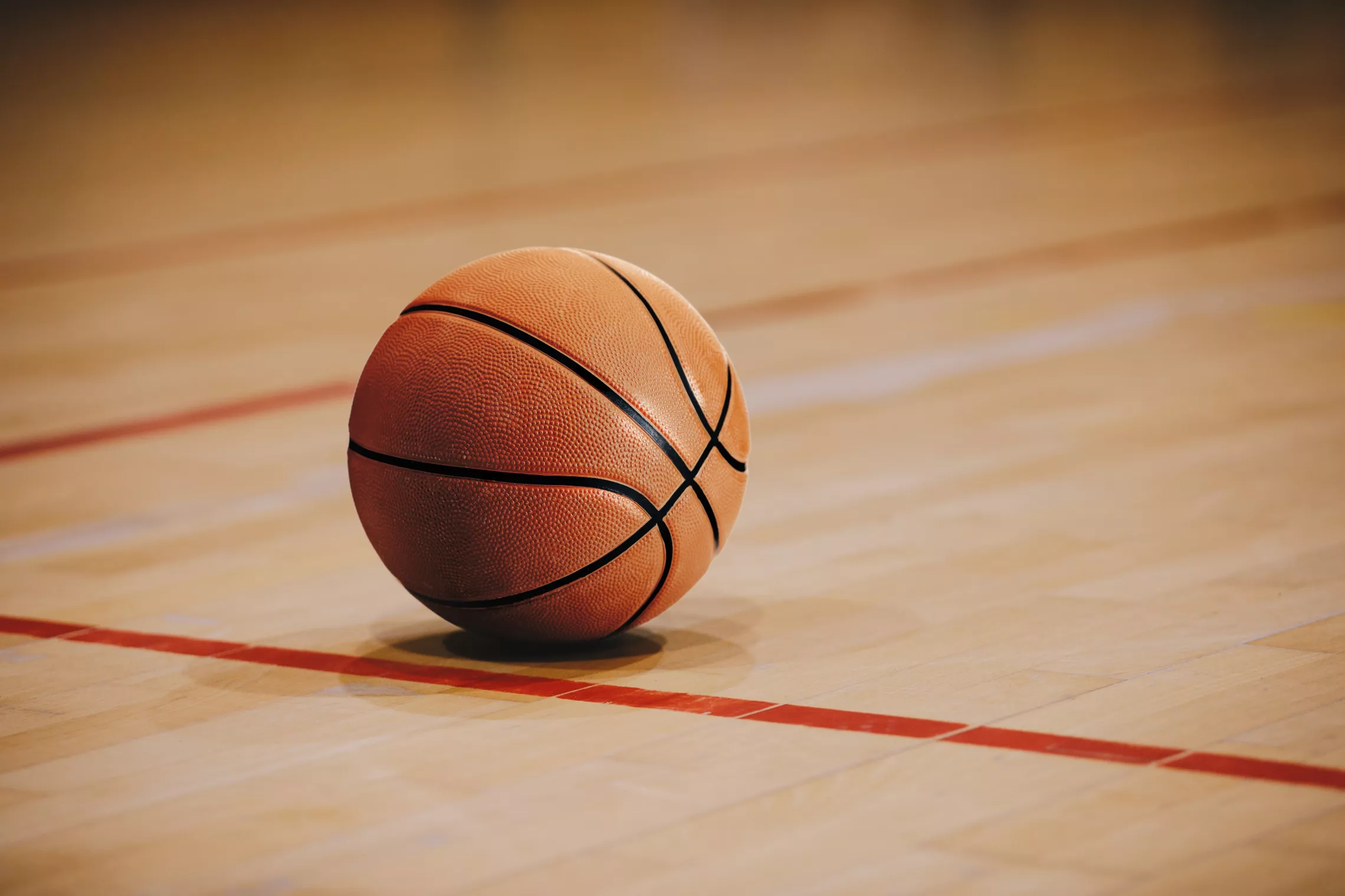 A basketball on a gymnasium floor.