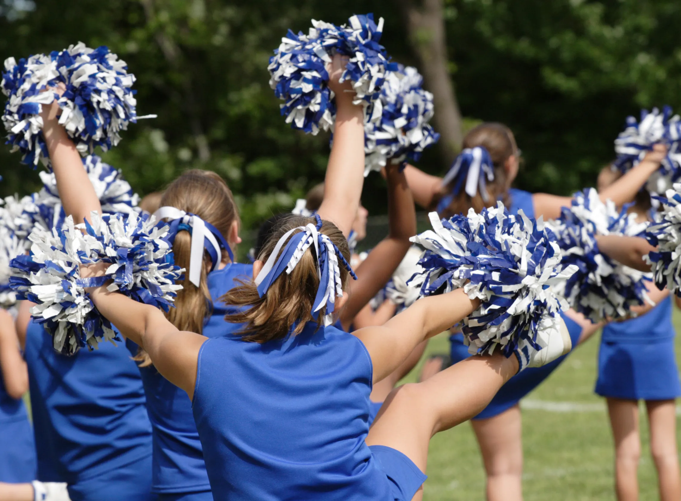 A group of cheerleaders wearing blue uniforms.