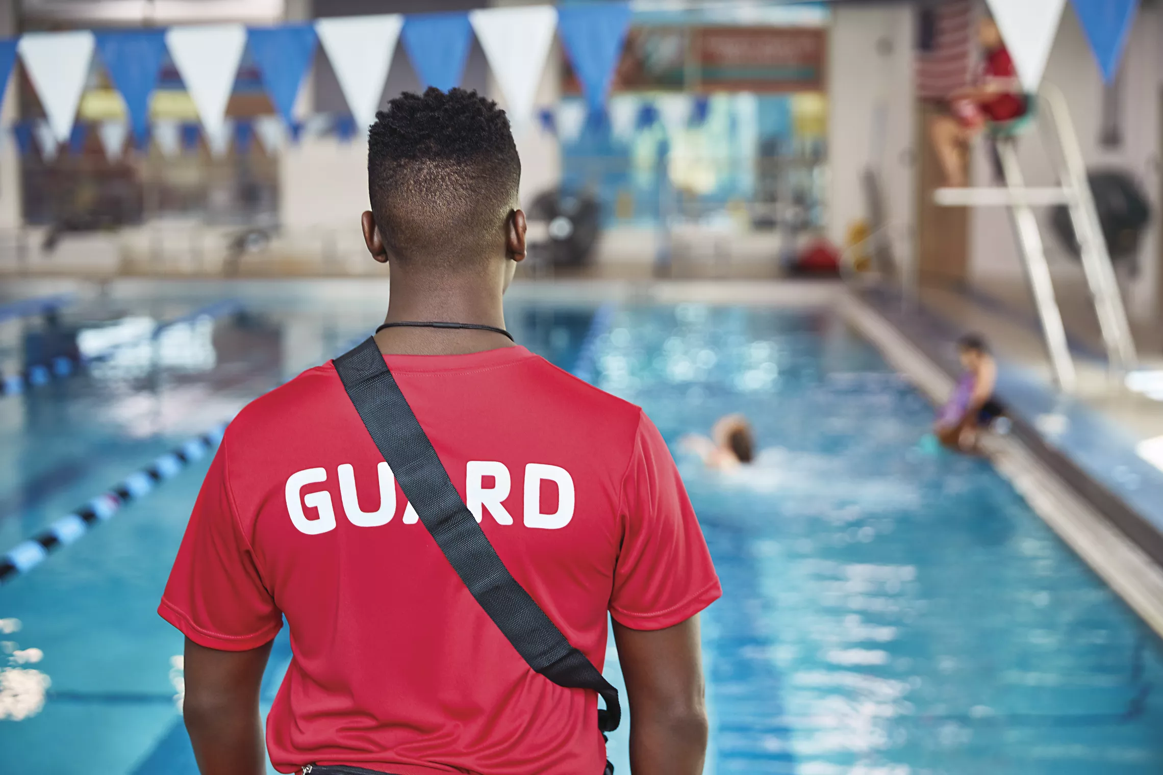 A YMCA lifeguard observes the pool.