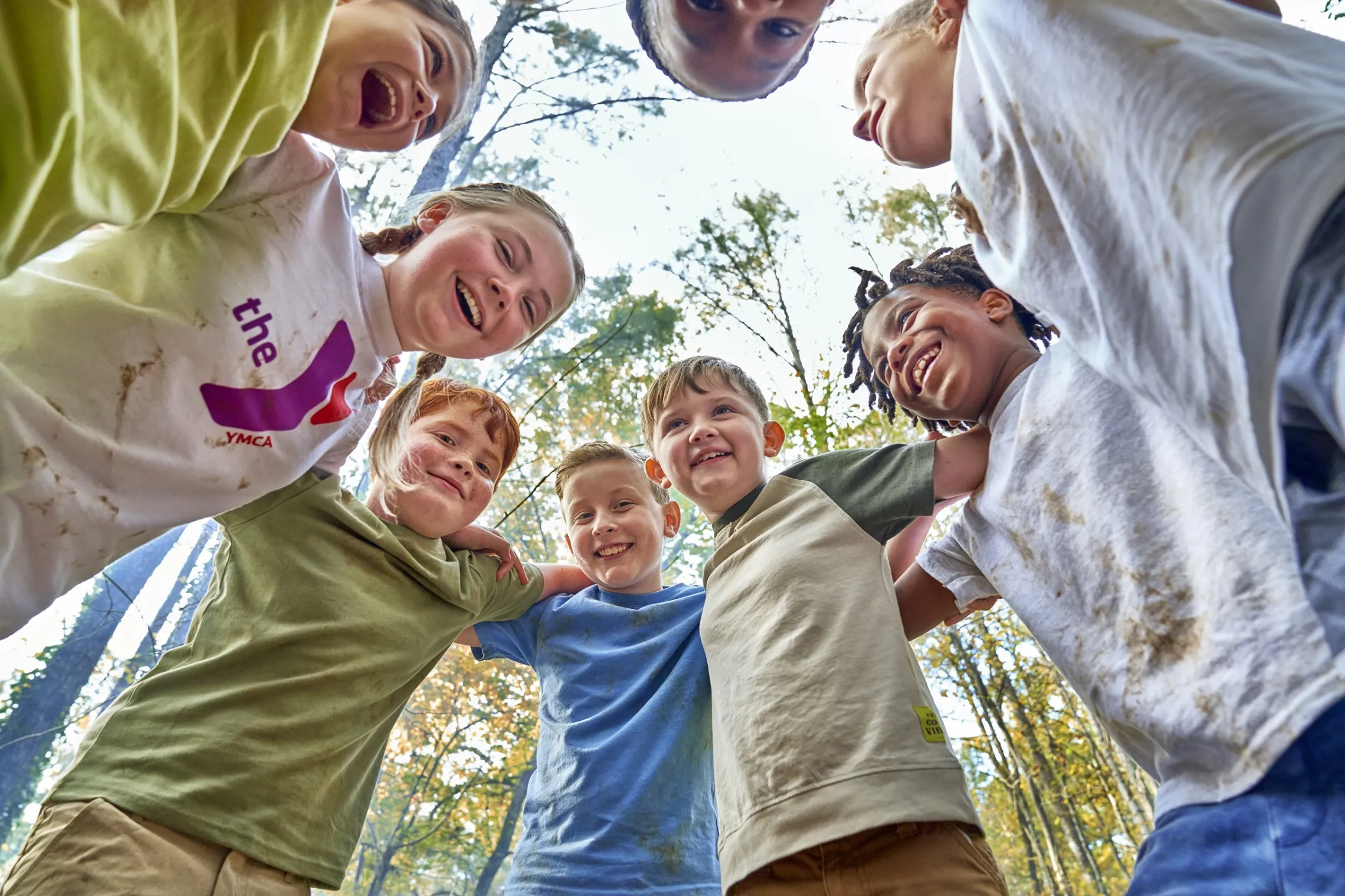 A group of kids smiling and laughing as they play together outside.