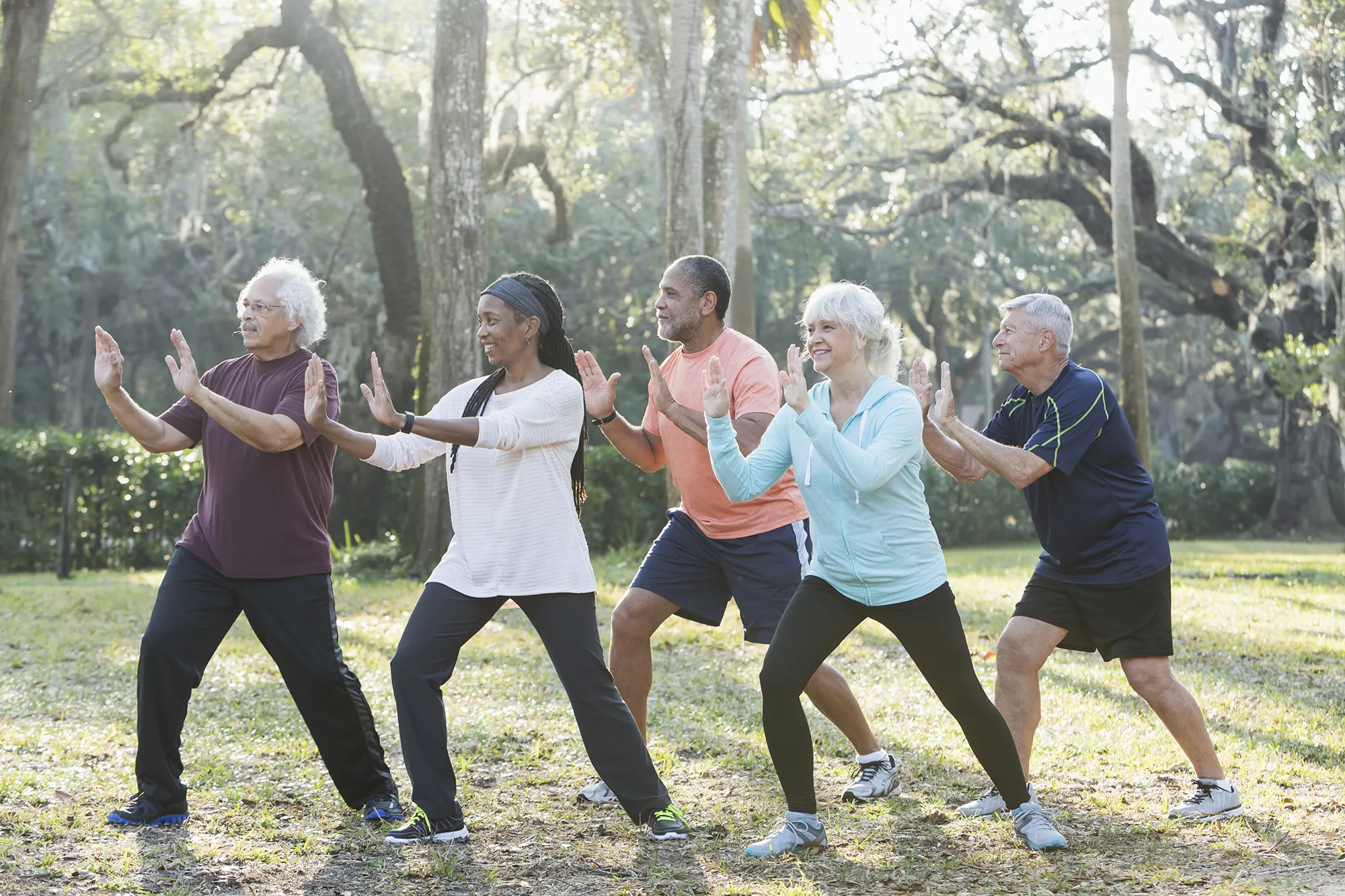 Individuals practicing Tai Chi outside.