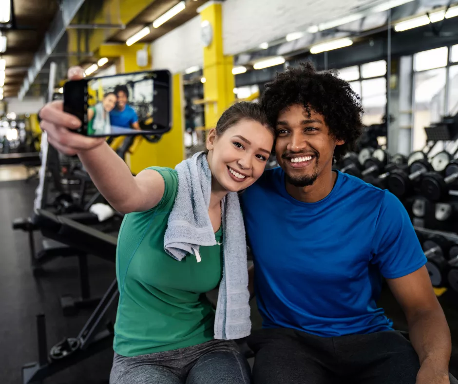 A couple taking a selfie at the gym