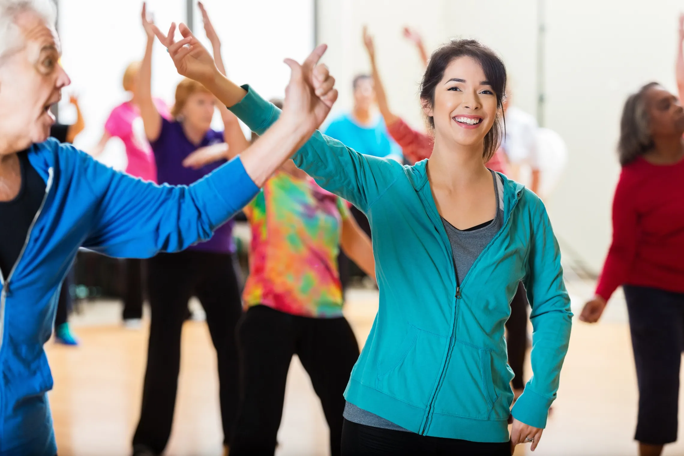 A group of people smiling and laughing while dancing.