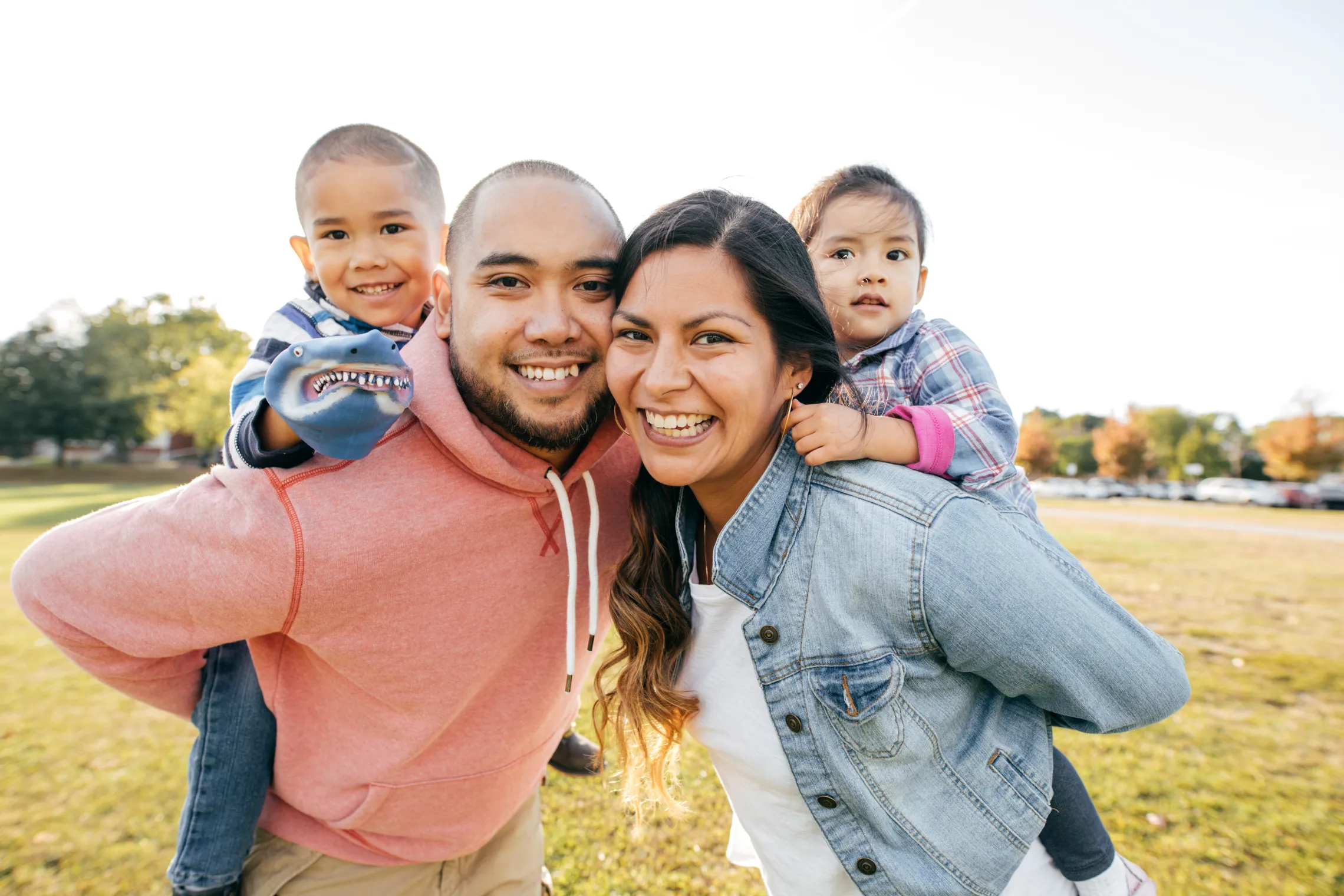 A family having fun together outside. They are smiling at the camera.