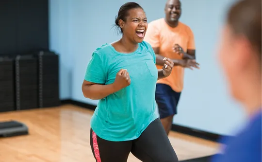 Woman in fitness class - excited and happy
