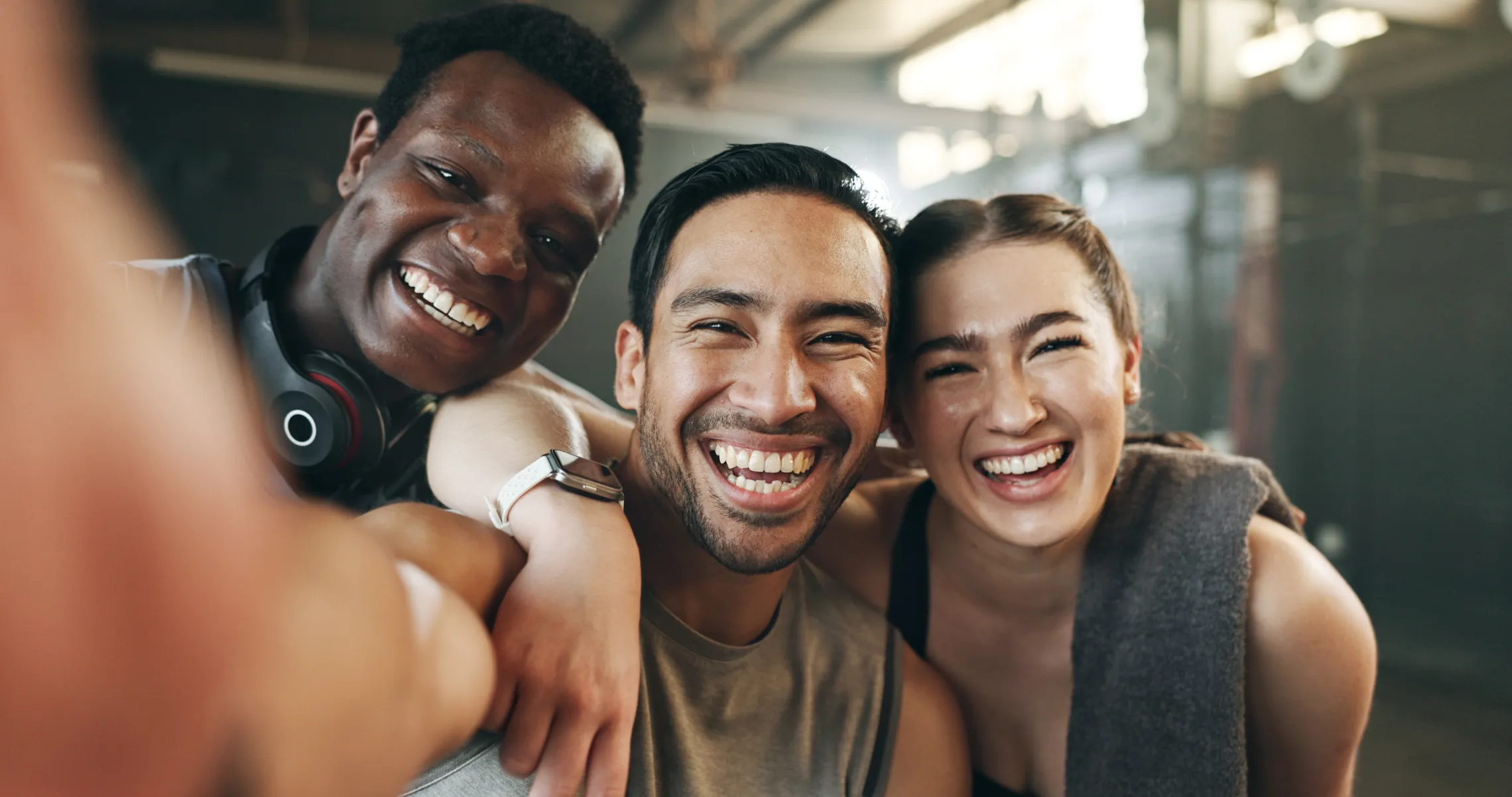 A group of friends at the gym smiling at the camera.