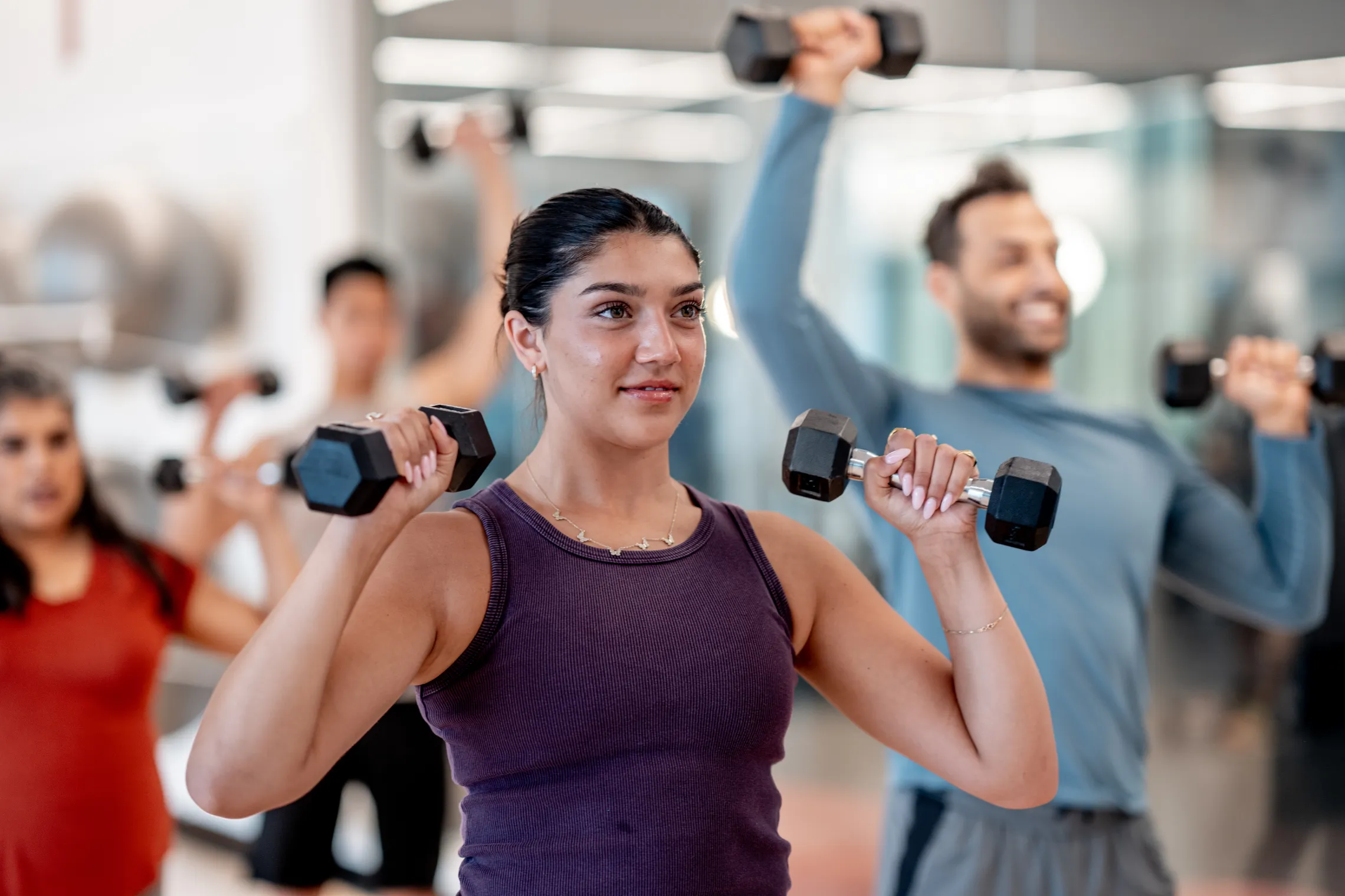 A woman using hand weights in a group exercise class.