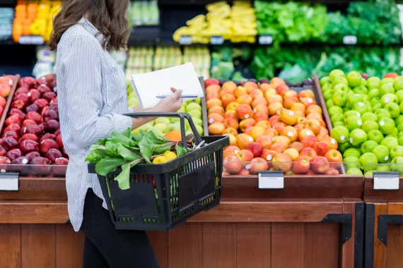 Woman buying vegetables in the groceries store