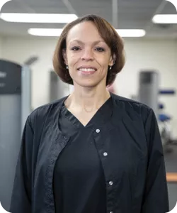 A portrait of Deirdre Moyer, personal trainer at the Eden YMCA. She is smiling at the camera.